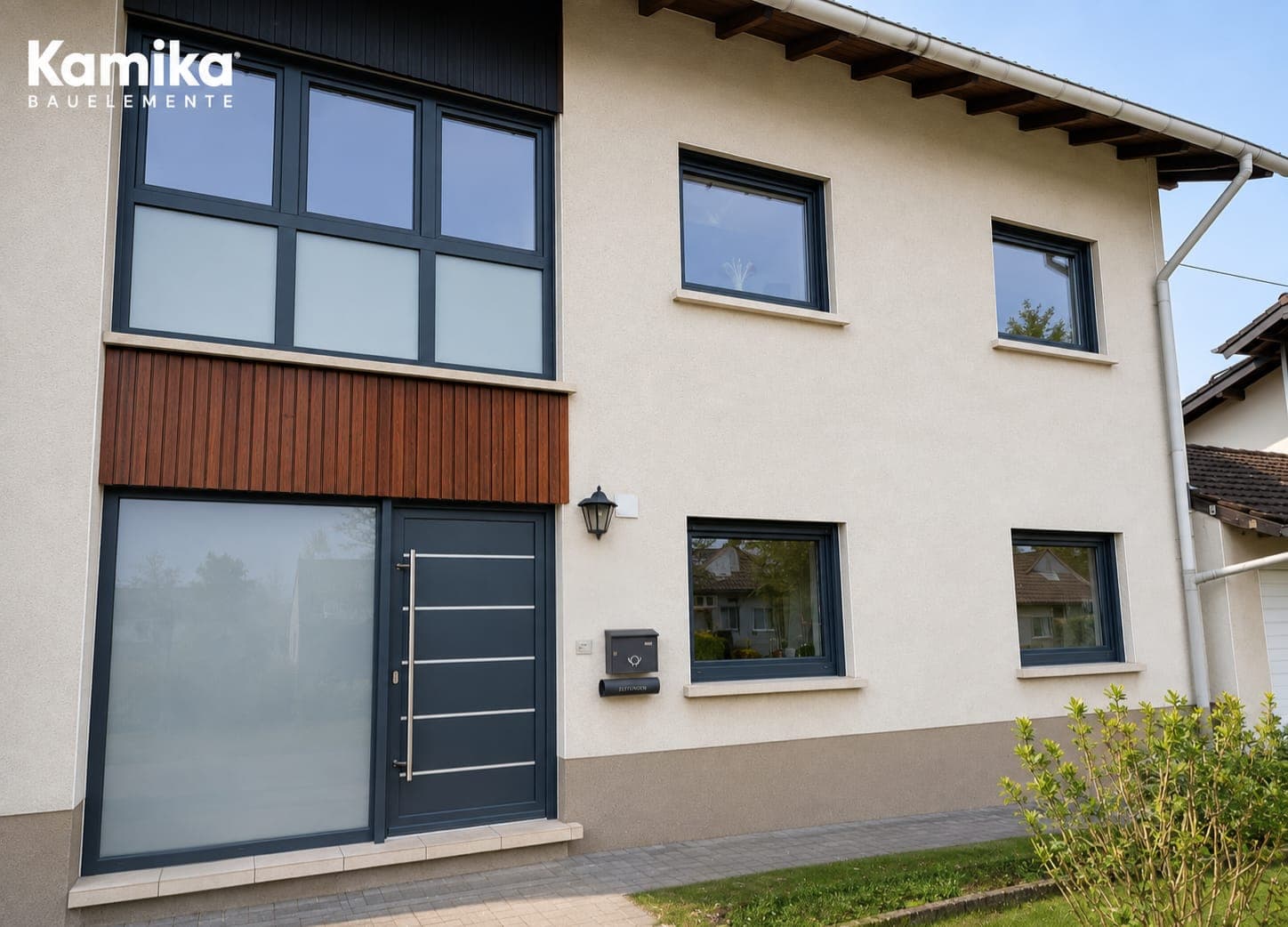 Hausfront mit anthrazitfarbener Haustür, Seitenteil und darüberliegendem Treppenhausfenster